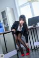 A woman in a business suit sitting at a desk.