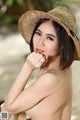 A woman in a straw hat posing for the camera.