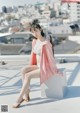 A woman sitting on top of a white box on a roof.